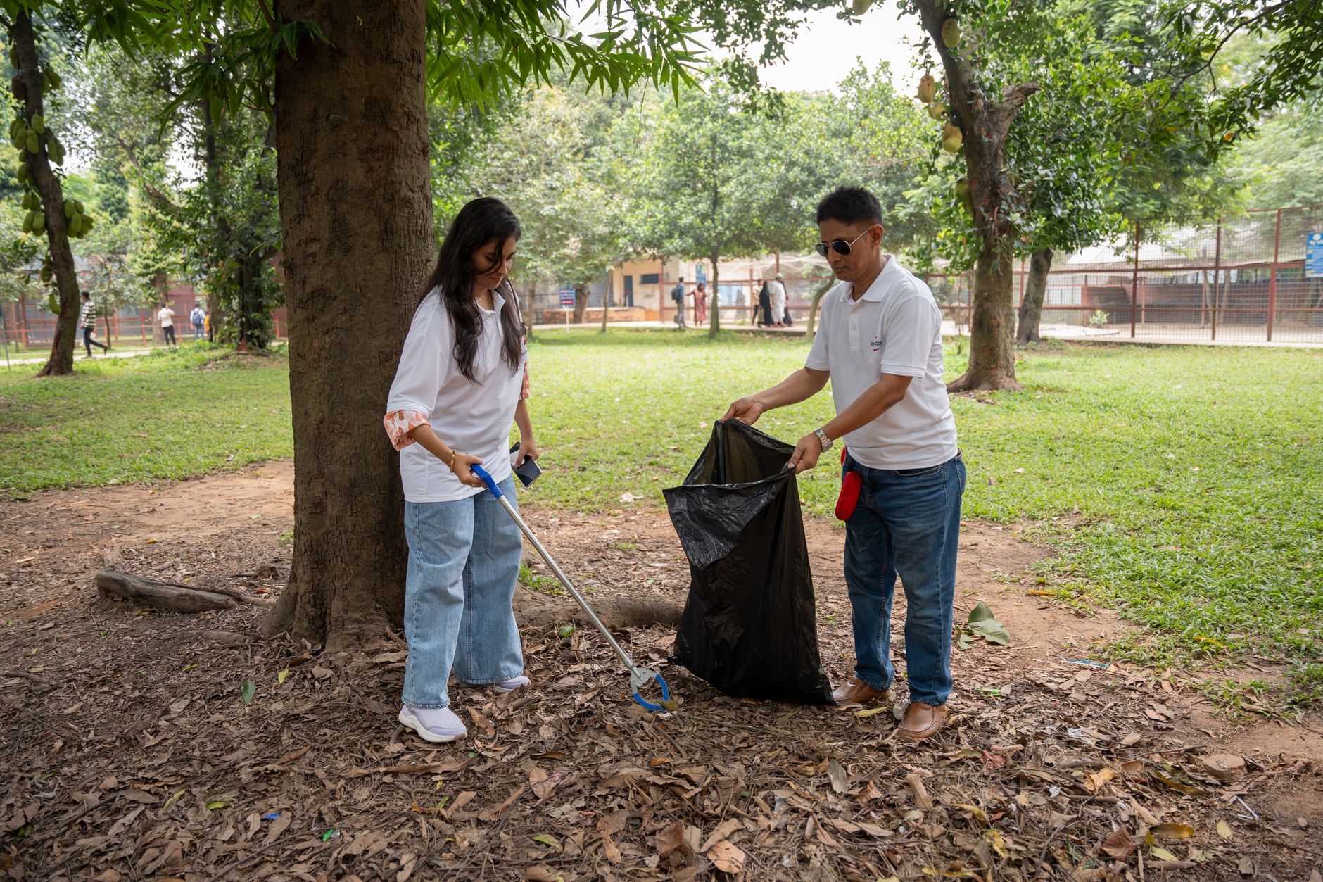 Volunteers in high-vis vests taking part in a litter-picking campaign at a UK urban park