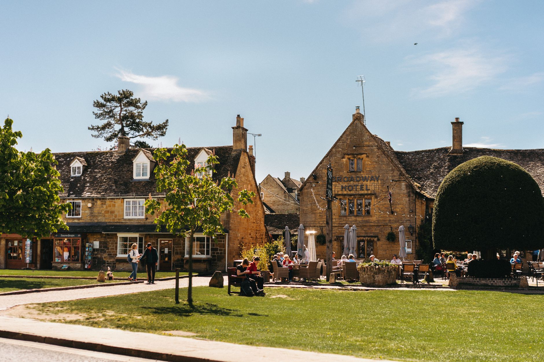 Village fête organisers setting up stalls on a sunny English village green with bunting and gazebos
